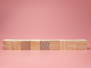 An empty wooden cube lined up on a pink background. For new ideas to be put into the picture.