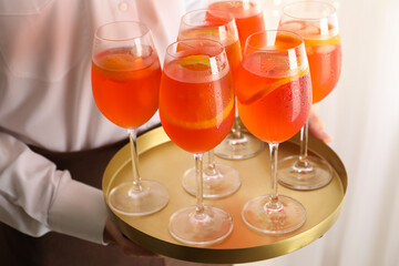 Waiter holding tray with aperol spritz cocktail. Summer drink