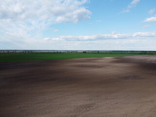 Picturesque farmland, aerial view. Beautiful sky over a plowed field.
