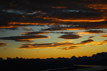 Dramatic sky cluds. Orange lenticular cluds. Sunset. South Patagonian sky.
