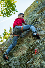 Naklejka na ściany i meble Male rock climber on challenging route