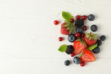 Mix of fresh berries on wooden background, space for text