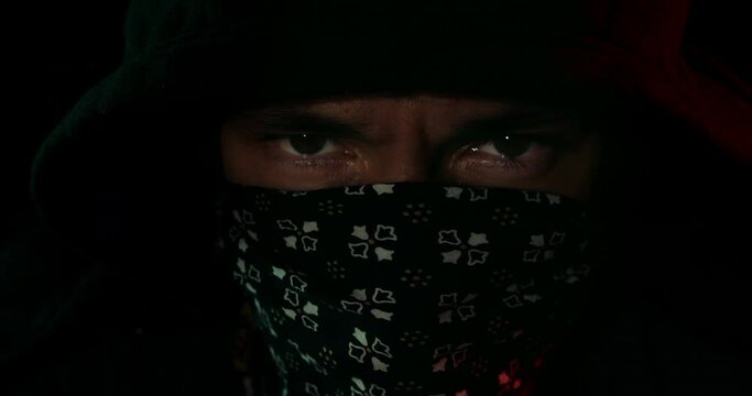 Hooded masked man staring into the camera.