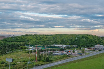 Fototapeta na wymiar Dump on the outskirts of Moscow. A hill overgrown with trees, a former city dump in the North of Moscow. Aerial view