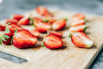 cut in half ripe fresh strawberries on a wooden Board on the table