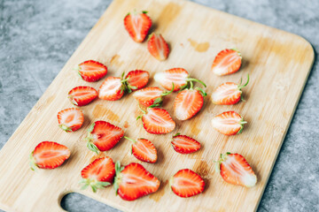 cut in half ripe fresh strawberries on a wooden Board on the table