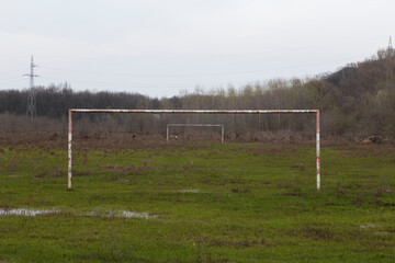 Goal posts from an empty, damp and muddy countryside football pitch