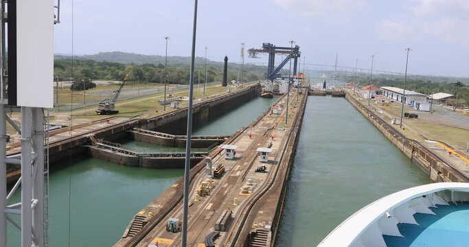 Panama Canal Pacific Ocean last locks POV. System lifts a ship 85 feet between the Atlantic and Pacific Ocean. Nation 52 miles long. Tug boats, electric train engines pull the cargo. Thousands ships.