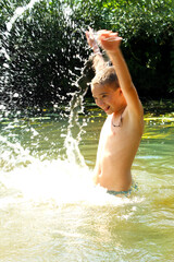 A boy plays in the water in summer.