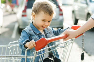Cute little boy sitting in a shopping cart