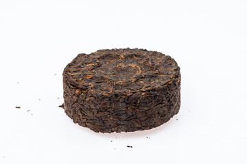 pressed black tea next to a cup of tea on a white background