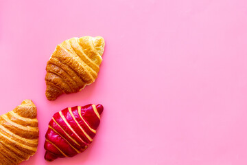 Set of croissants - berry, classic - on pink background top view