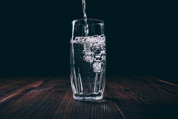 Water is poured into a transparent glass