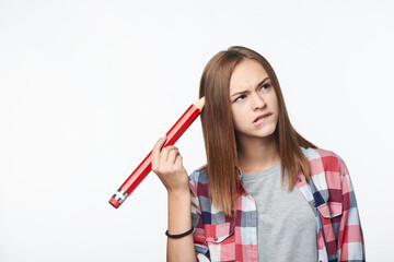Contemplating girl scratching her head with big pencil