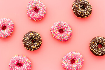 Donuts flat lay pattern on pink background, top view