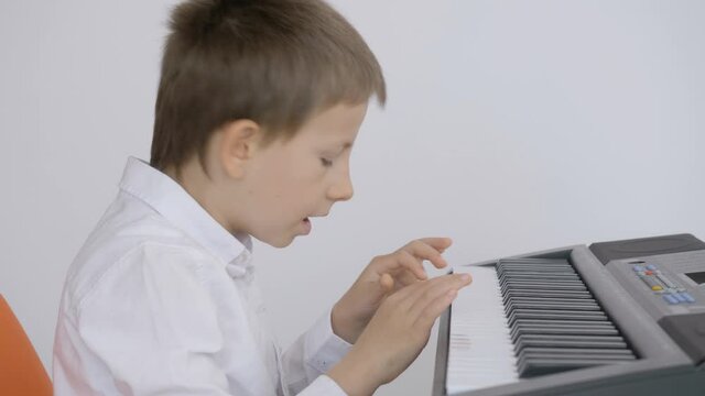 Boy with shirt learn to play at piano, mistake and retake