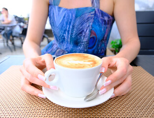 Beautiful girl with cup of coffee outdoors.