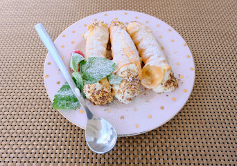 Cannoli Siciliani - traditional dessert stuffed with ricotta cream and nuts with raspberry and mint leaves