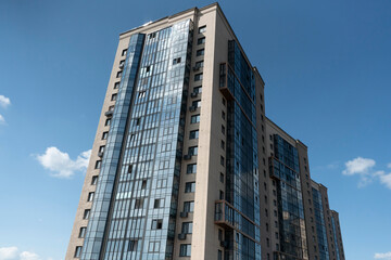 Fototapeta na wymiar Multi-storey buildings against a blue sky with clouds.