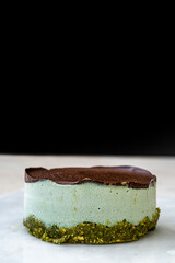 Vegan Raw Round Cheesecake with Mint, Bitter Chocolate and Pistachio Nut Paste.