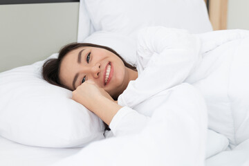 Obraz na płótnie Canvas Young Woman Sleeping In Bed. Portrait Of Beautiful Female Resting On Comfortable Bed With Pillows in the morning. Happy woman sleeping on a pillow in bed and smiling. Pretty young girl on white bed.
