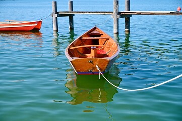 Obraz premium Small wooden boat on pier. Chiemsee lake in Bavaria.