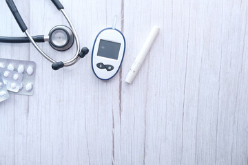 top view of diabetic measurement tools and pills on wooden background 