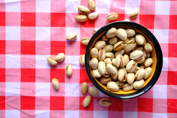 Top view pistachios nut in a bowl on table cloth 
