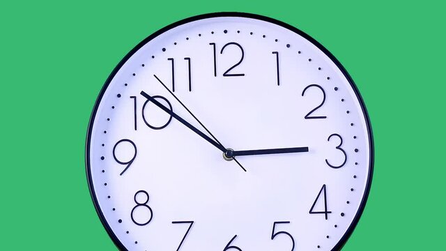 Footage of contemporary,trendy office clock with white dial and black numerals,showing ten minutes to three,it's almost time to finish work.Studio shot on green background.Business,work concept.