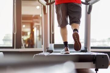 Close up foot sneakers Fitness man running on track treadmill, Man with muscular legs in exercise gym.