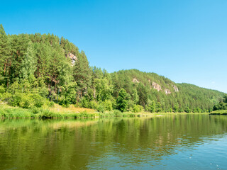 Fototapeta premium Nature, river, mountains, forests on a summer day, Rocky shore with the forest.