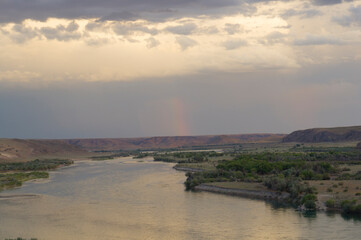 River valley in Kazakhstan. Beautiful river and rainbow in the sky after rain.
