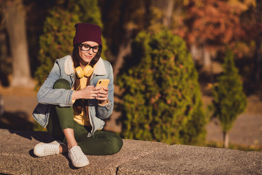 Portrait of her she nice attractive pretty focused cheery girl blogger using 5g app device browsing post share social network blogging spending sunny day October outdoor outside fresh air