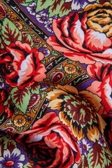 top view closeup on crumpled colorful cotton scarf with red roses floral ornament