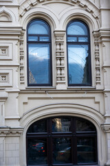 Obraz premium reflection of the sky and clouds in the windows of old houses