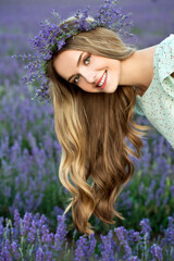 Beautiful girl in lavender wreath and retro dress on the lavender field. Beautiful woman in the lavender field on sunset in France .Girl collect lavender.Soft focus. Series.