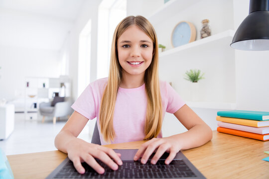 Close up photo of small kid girl study remote use laptop have online teacher conversation lesson texting hands keyboard sit comfort cozy table in house indoors
