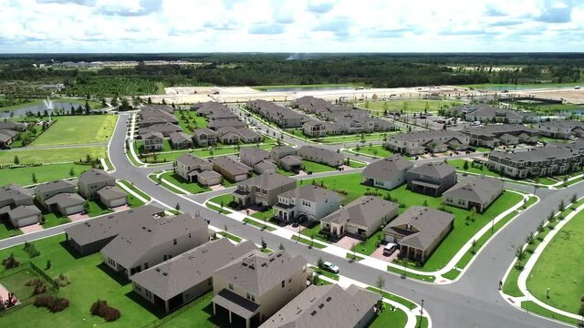 Aerial View Of An Upper Middle Class Lakefront Neighborhood Subdivision With Single Family Homes And Townhouses, Pool And Clubhouse On A Cloudy Fall Day In Winter Garden, Florida, USA.