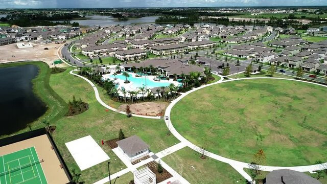 Aerial View Of An Upper Middle Class Lakefront Neighborhood Subdivision With Single Family Homes And Townhouses, Pool And Clubhouse On A Cloudy Fall Day In Winter Garden, Florida, USA.