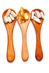 three spoons with fish oil and multivitamins isolated on white. top view