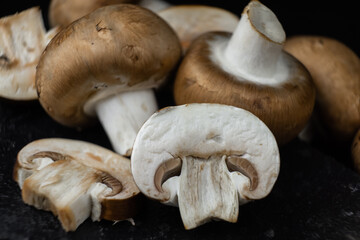 Fresh champignon mushrooms on black background, close up