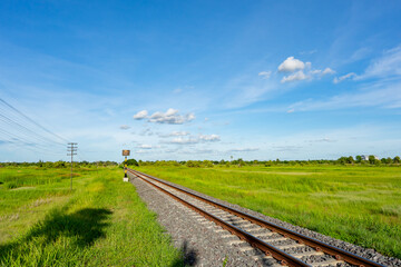 Railway on grass field on blue sky background