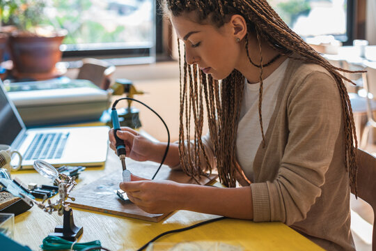 Portrait of woman using soldering iron stock photo