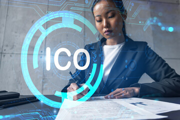 A woman signs contract and ico symbol hologram. Concept of initial coin offering. Multiexposure....