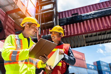 Smart Engineer or supervisor checking and control loading Containers box from Cargo at...