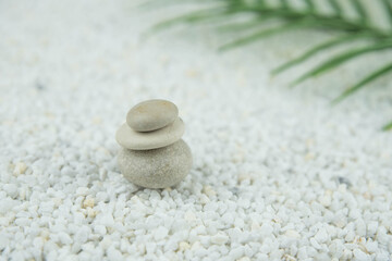 Fototapeta na wymiar Pyramids of gray and white zen pebble meditation stones on white background. Concept of harmony, balance and meditation, spa, massage, relax