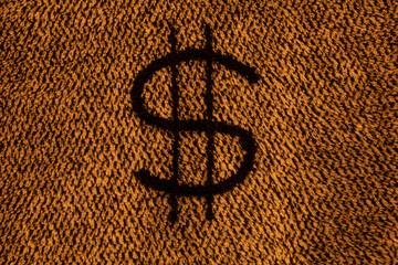 Texture of a dark yellow woolen product with the image of the dollar symbol