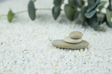 Fototapeta na wymiar Pyramids of gray and white zen pebble meditation stones on white background. Concept of harmony, balance and meditation, spa, massage, relax