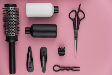 Professional hair dresser tools with copy space. Hair stylist equipment set on pink background. Scissors, brush, hairbrush, balm flat lay top view.