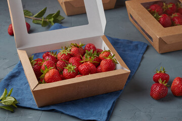 Strawberries in eco carton packaging, vegetarian food, gray background